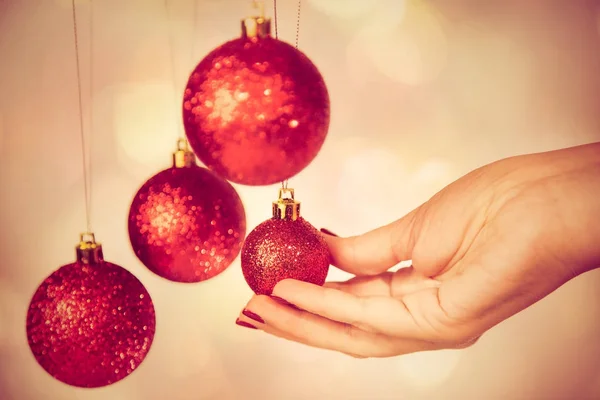 Vermelho redondo bolas de Natal e mão feminina — Fotografia de Stock