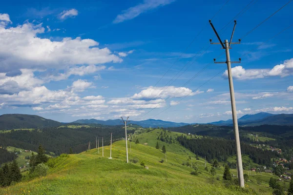 Alte rostige Stromleitungen an malerischen grünen Hügeln — Stockfoto