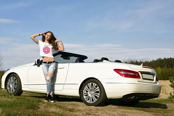 Beautiful sexy woman in a white cabriolet.
