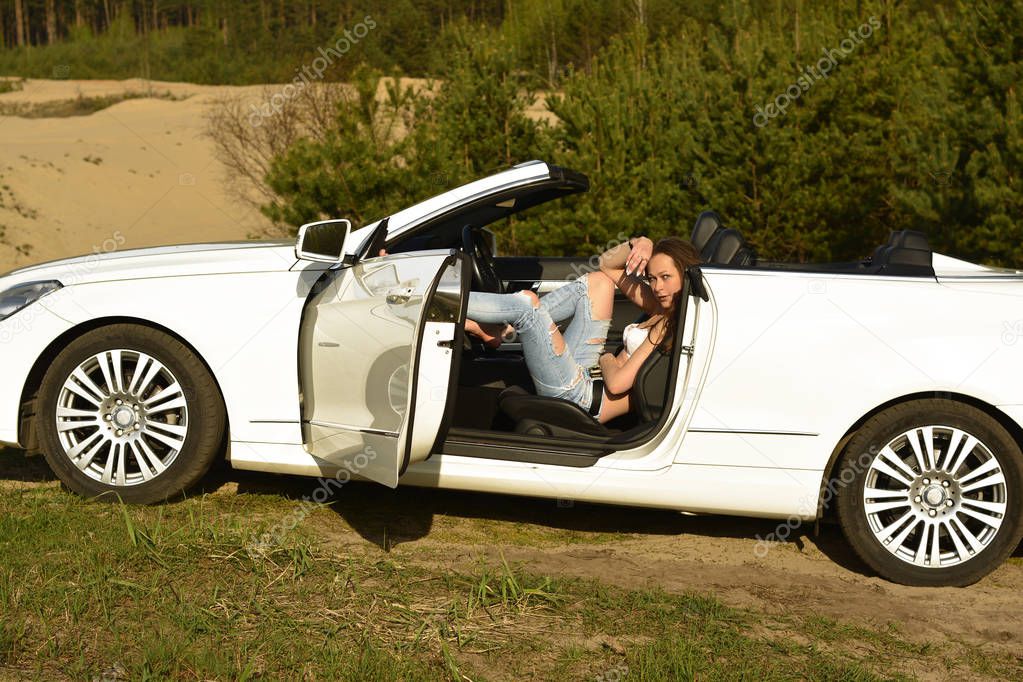Beautiful sexy woman in a white cabriolet.