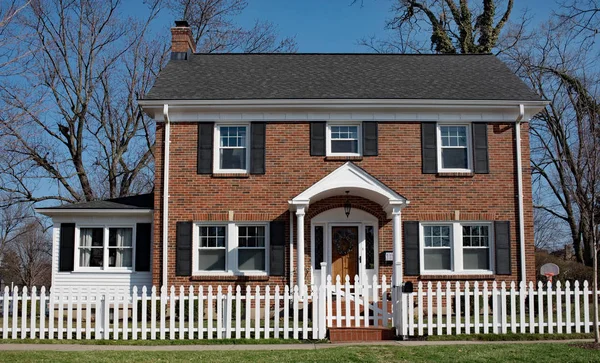 Brick House med White Picket Fence – stockfoto