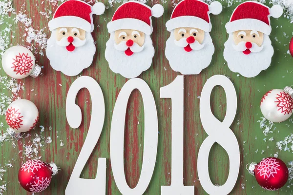 Fundo Ano Novo 2018 com números, rostos de Papai Noel, bolas — Fotografia de Stock