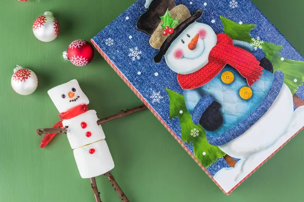 Wenskaart met marshmallow sneeuwpop en gift box met sneeuwpop. — Stockfoto