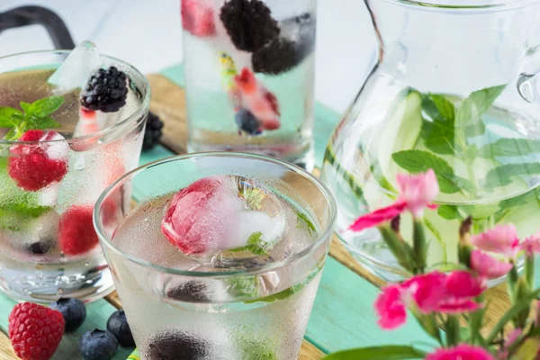 Glasses of water with ice cubes with fresh berries. — Stock Photo, Image