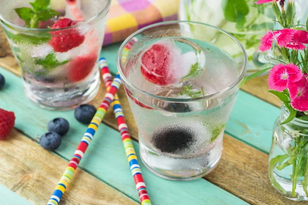 Vasos de agua con cubitos de hielo con bayas frescas . — Foto de Stock