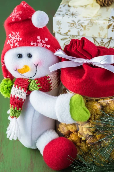 De gift van Kerstmis - sneeuwpop pot met karamel popcorn. — Stockfoto