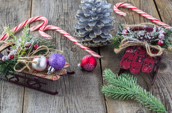 Kerstbal met Kerstmis sleeën en pinecone. — Stockfoto