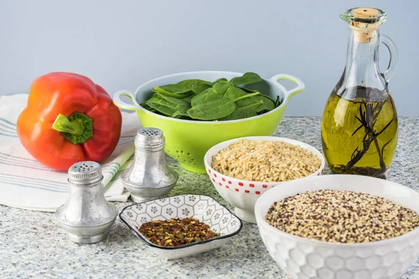 Cooked spinach quinoa brown rice with vegetables and berries.