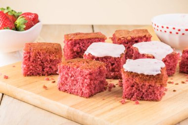 Kesme tahtasındaki çilekli pastayı kes..