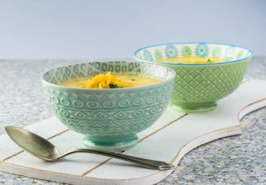 Mutfak masasında iki kase ev yapımı brokoli peynirli peynir çorbası..