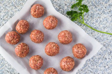 Parşömen kağıdında çiğ köfteler - fırınlanmaya hazır.