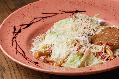 Üzerine peynir serpilmiş et serpilmiş sebze salatası.