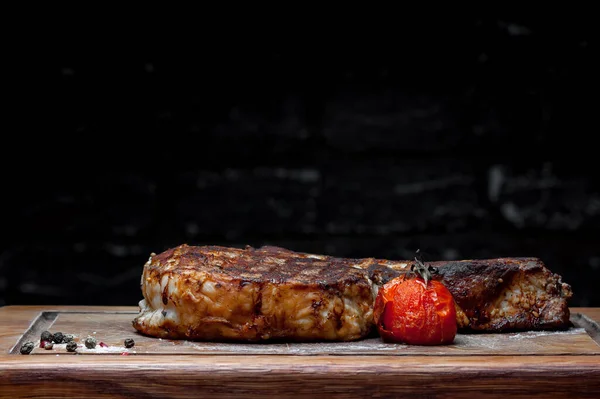 Steak Auf Einer Tafel Auf Schwarzem Hintergrund — Stockfoto