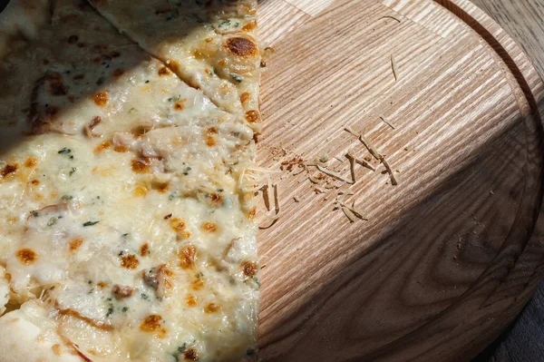 Meia Pizza Uma Bandeja Madeira Está Uma Mesa Iluminada Pelo — Fotografia de Stock