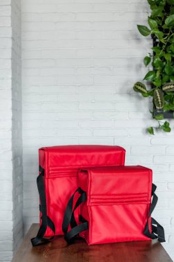 Farklı boyutlarda iki çanta ve yiyecek teslimatı için kırmızı.