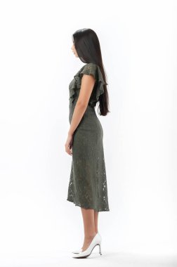 Esmer, beyaz arka planda bir katalog için kıyafetlerle poz veriyor.