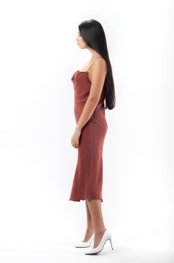 Esmer, beyaz arka planda bir katalog için kıyafetlerle poz veriyor.