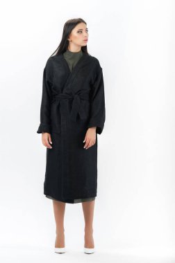 Esmer, beyaz arka planda bir katalog için kıyafetlerle poz veriyor.