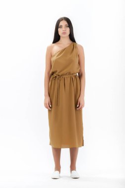 Esmer, beyaz arka planda bir katalog için kıyafetlerle poz veriyor.