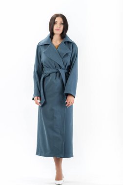 Esmer, beyaz arka planda bir katalog için kıyafetlerle poz veriyor.