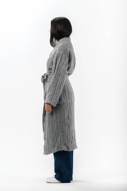 Esmer, beyaz arka planda bir katalog için kıyafetlerle poz veriyor.