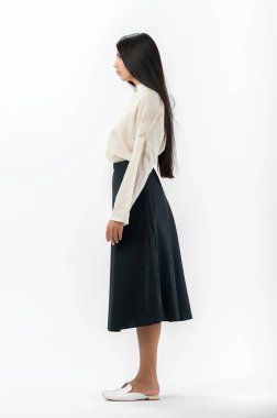 Esmer, beyaz arka planda bir katalog için kıyafetlerle poz veriyor.