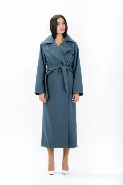 Esmer, beyaz arka planda bir katalog için kıyafetlerle poz veriyor.