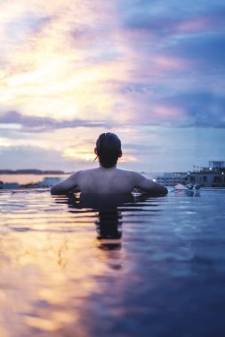 bir adam yaz aylarında su günbatımı gökyüzü altında dinlenmek