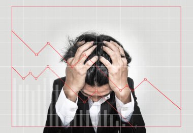Stressed out businessman, with downward business graphs. Failure stock market and loss business investment profit concepts clipart