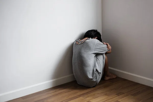 Depressieve jongeman, zit alleen in de hoek van de kamer, verdriet, depressief, en leven problemen concept — Stockfoto