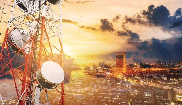 Çift pozlama iletişim direkleri ile Tv antenleri ve günbatımı, şehir geçmişi olan uydu çanağı