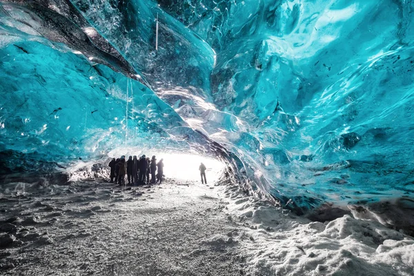 Caverna de gelo de paisagem, com grupo de silhueta de turista e luz solar brilhante da entrada de caverna — Fotografia de Stock