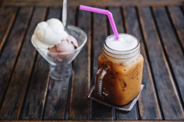 Yaz tatlı, dondurma ahşap masa, seçmeli tarih ile buzlu kahve kahve fincanı üzerinde odaklanmak