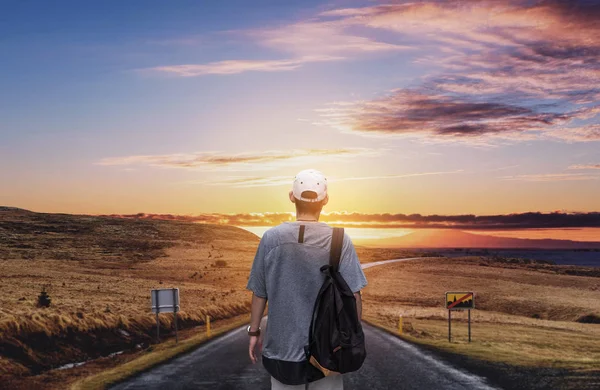 Junger Reisender mit Rucksack, der morgens im Stehen die herrliche Aussicht auf die Sonnenaufgangslandschaft genießt — Stockfoto