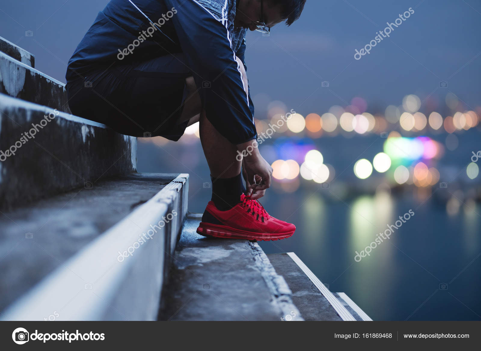 a guy tying running shoe preparing for running in the dawn bokeh shoe backgrounds
