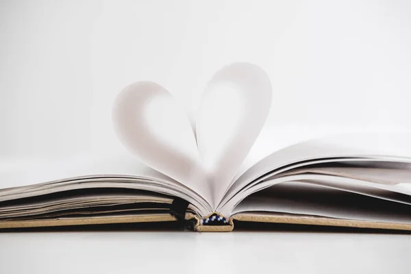 Forma del corazón en la página del cuaderno abierto, sobre fondo blanco — Foto de Stock