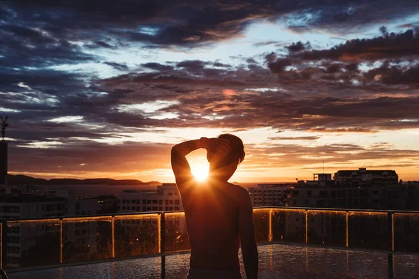 夏の夕暮れ時、市内のプールに立っている男性 — ストック写真