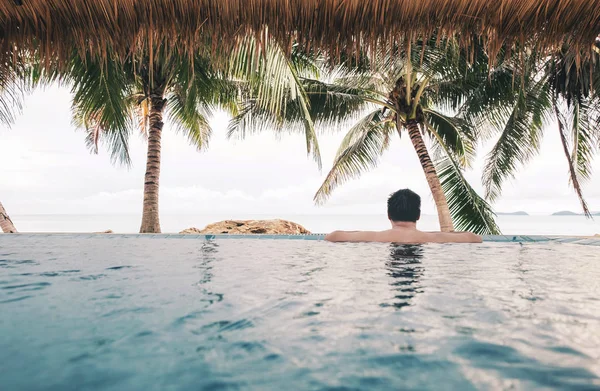 Rilassatevi in piscina nel resort tropicale sulla spiaggia in estate — Foto Stock