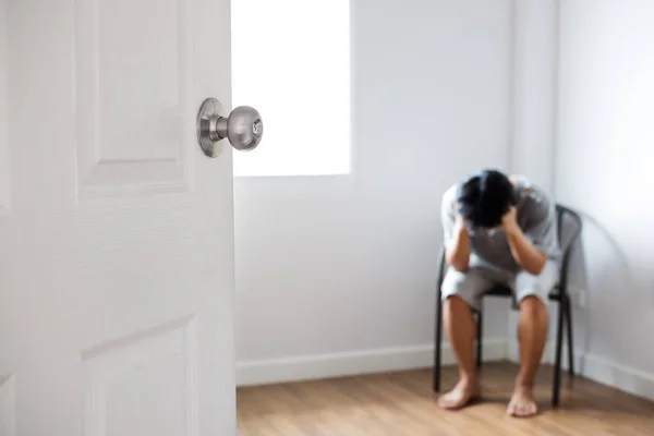 Porta aperta con ragazzo depresso seduto in un angolo della stanza vuota — Foto Stock