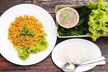 Geleneksel Tayland gıda, curcuma herb ile kızarmış balık hizmet taze sebze ile ince pirinç şehriye ve deniz ürünleri baharatlı yiyecek