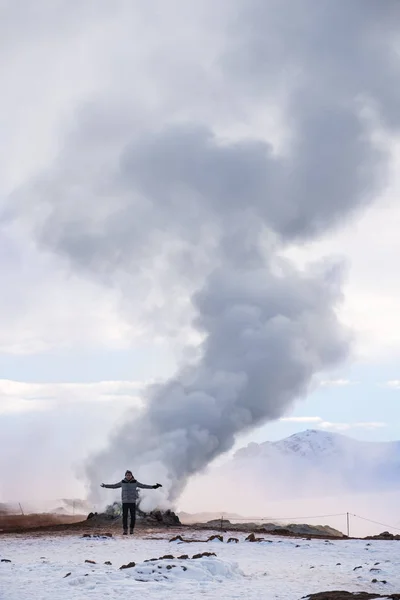 Viaggiare in Islanda, un uomo con fumo dal sottosuolo in zona geotermica Hverir in inverno, Islanda — Foto Stock