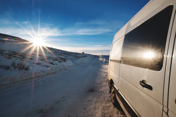 Samochód na bocznej drodze w zimowy poranek, słońce i flary — Zdjęcie stockowe