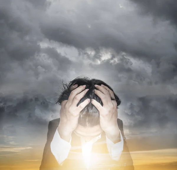 Homme d'affaires stressé avec nuage sombre et double exposition lever de soleil ciel, espoir et problèmes d'affaires concept Photo De Stock