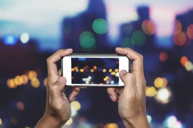 Fotoğrafta akıllı telefon tarafından Bokeh ışıklar alarak smartphone holding eller
