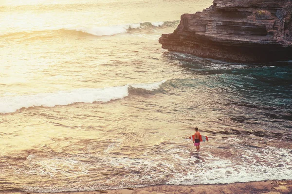 A man with surfboard standing on the beach in sunset, vintage tone — Stock Photo, Image