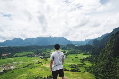 dağ tepe üzerinde duran, tropikal kırsal, Vang Vieng Laos'de seyahat bir adam