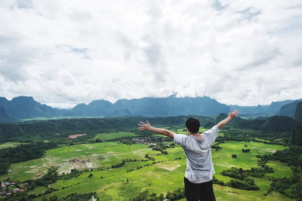el kadar dağ tepe üzerinde yükselterek, tropikal kırsal, Vang Vieng Laos'de seyahat bir adam
