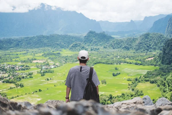 Joven con mochila disfrutando de una hermosa vista de la naturaleza ajardinada en la cima de la montaña en Laos, Viajando actividad de ocio senderismo al lugar de interés — Foto de Stock