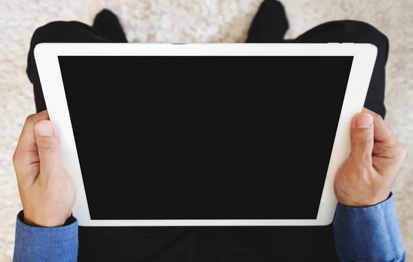 Чоловік у синій сорочці тримає цифровий планшетний комп'ютер, відсікаючий контур порожній чорний екран — стокове фото