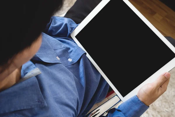 Um homem usando computador tablet digital, sentado na cadeira moderna, cortando caminho tela preta vazia — Fotografia de Stock